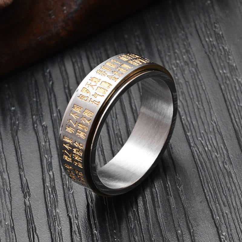 Bagua Yin Yang Titanium Steel Rotatable Ring - two-tone silver and gold ring with Taoist symbols on dark sculptural stand,...