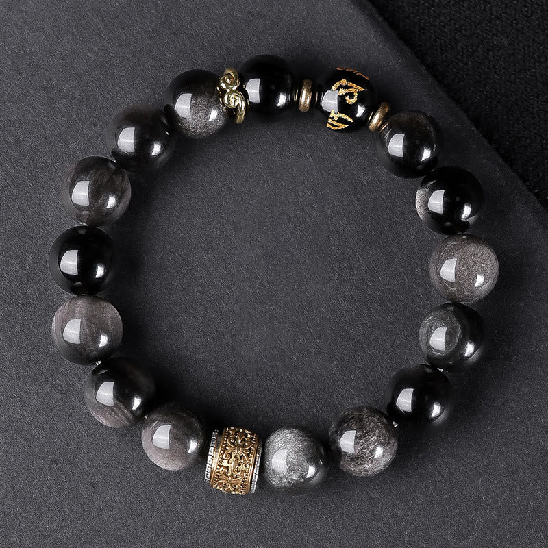 Om Mani Padme Hum Bracelet – Overhead on dark fabric, black obsidian with gold mantra bead