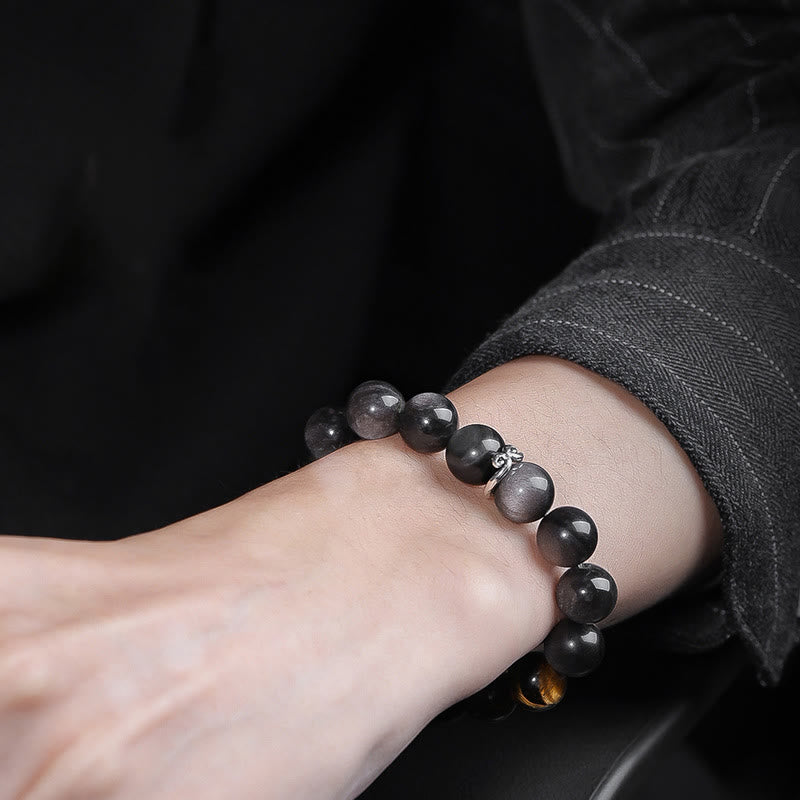 Om Mani Padme Hum Bracelet – Worn on wrist with dark sleeve, moody lifestyle shot