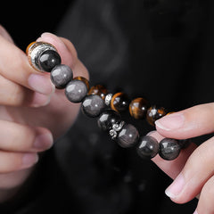 Om Mani Padme Hum Bracelet – Hand-held close-up revealing polished obsidian and tiger eye stones