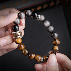 Om Mani Padme Hum Bracelet – Held between hands, dark atmospheric background, beaded bracelet