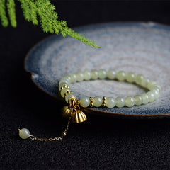Natural Hetian Jade Lotus Luck Bracelet - jade beads with lotus pod charms on ceramic plate, prosperous