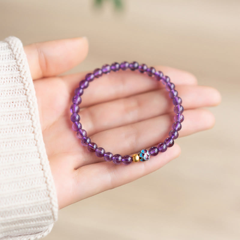 Natural Amethyst Lotus Spiritual Awareness Bracelet - purple amethyst resting in hand with knit sleeve, zen
