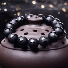 Black Onyx Mantra Bracelet – Obsidian beads with metallic inlay characters on ceramic dish, meditation beads