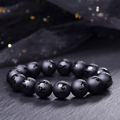 Black Onyx Mantra Bracelet – Matte black beads with carved Sanskrit characters on dark stone surface, black onyx bracelet