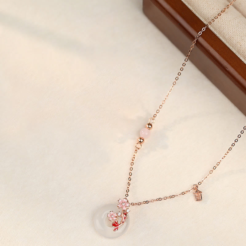 Chalcedony Koi Fish Peace Buckle Necklace – full necklace on cream, donut pendant with cherry blossom branch, tag charm