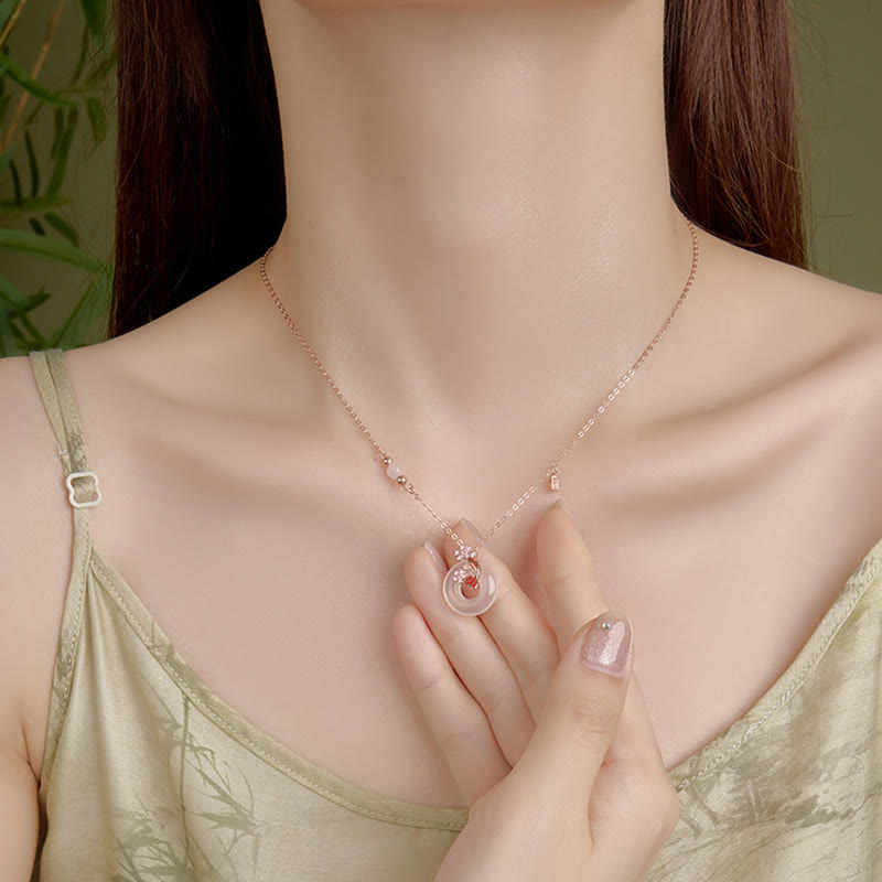 Chalcedony Koi Fish Peace Buckle Necklace – worn with hand touching double-circle pendant, sage camisole, olive wall