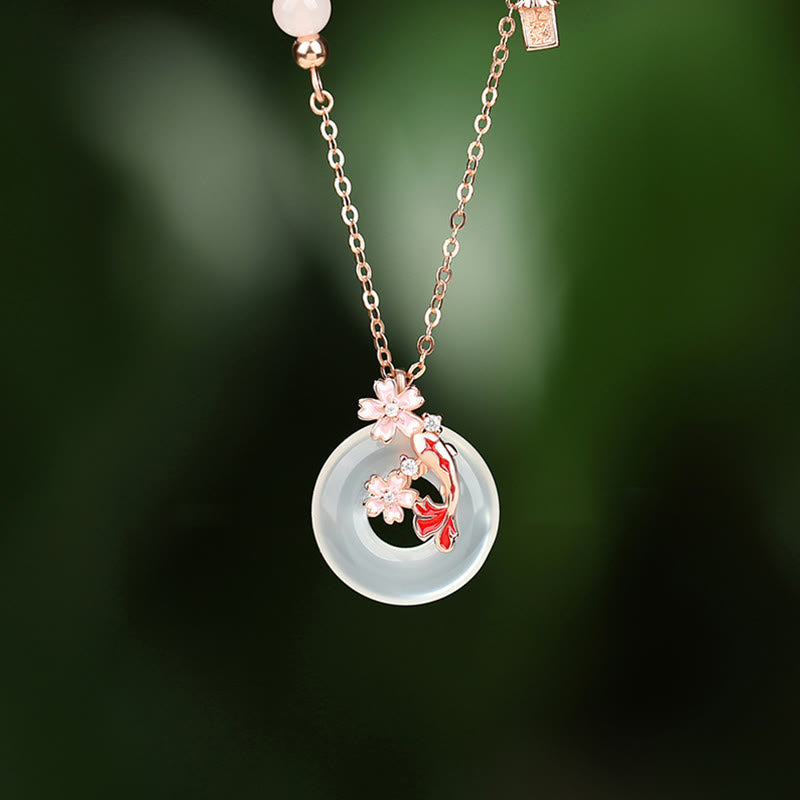 Chalcedony Koi Fish Peace Buckle Necklace – circular jade pendant with koi through center and blossoms, green foliage bg