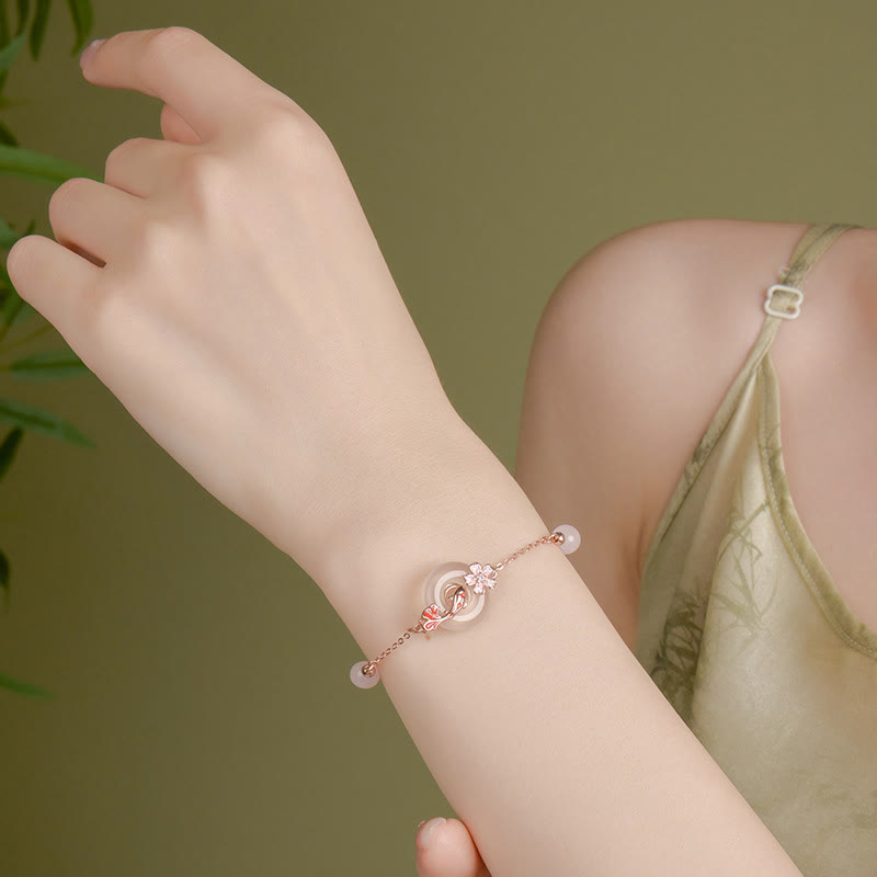 Chalcedony Koi Fish Peace Buckle Bracelet – side-profile wrist shot, interlocking jade element, olive foliage backdrop
