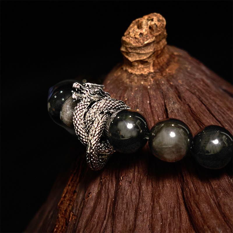 Silver Sheen Obsidian Dragon Bracelet – macro closeup of silver dragon head with obsidian beads on dark wood, powerful