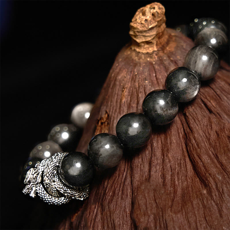 Silver Sheen Obsidian Dragon Protection Bracelet | Strength & Power – dragon head clasp on obsidian over driftwood, rugged