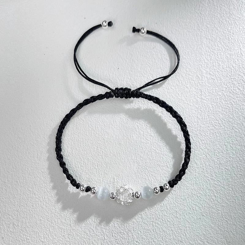 Sterling Silver Lotus Cat's Eye String Bracelet - black cord flat lay with sliding knot detail, serene