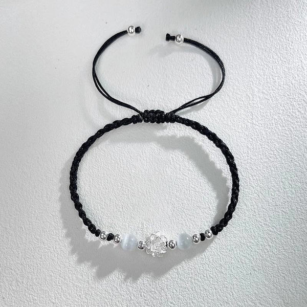 Sterling Silver Lotus Cat's Eye String Bracelet - black cord flat lay with sliding knot detail, serene