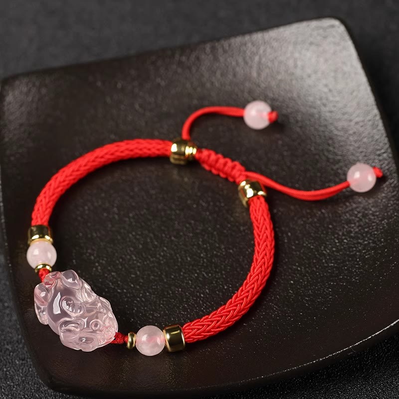 Pink Crystal PiXiu Bracelet – Red cord bracelet with pink crystal charm on black ceramic dish