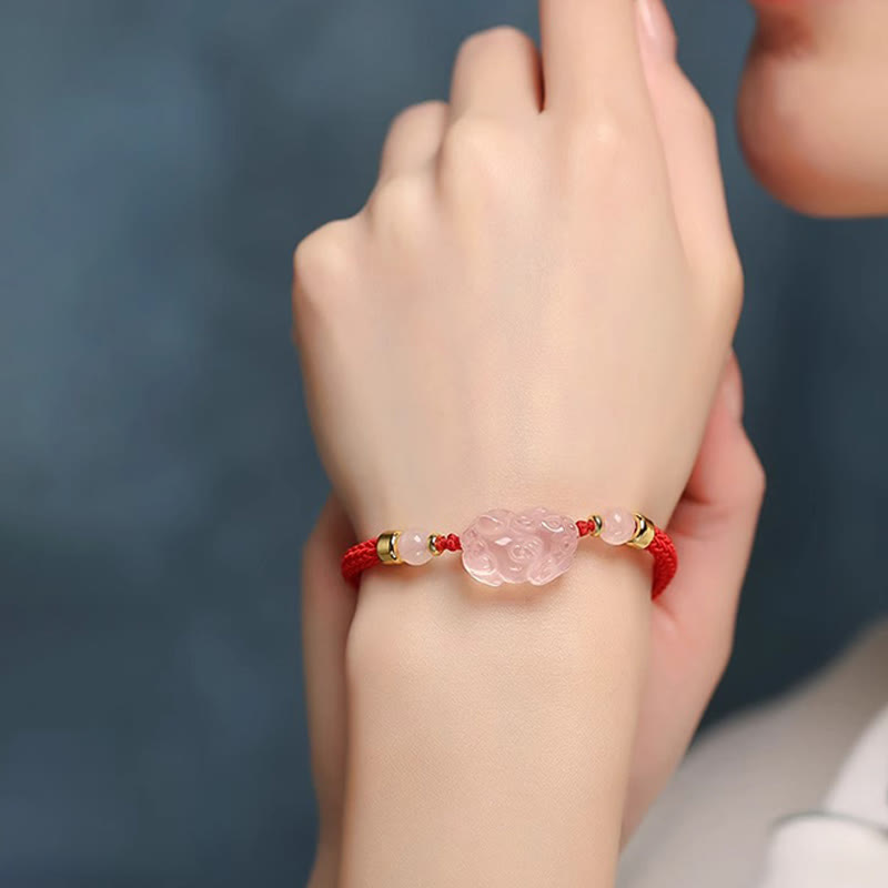 Pink Crystal PiXiu Bracelet – Model wrist shot with blue background, pink crystal charm