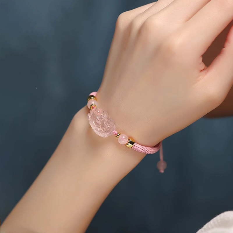 Pink Crystal PiXiu Bracelet – Pink cord bracelet on model wrist, blue background