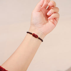 Garnet Cinnabar PiXiu Bracelet – worn on wrist beige background red sweater, cinnabar protection jewelry