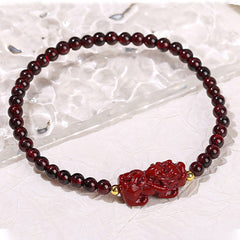 Garnet Cinnabar PiXiu Bracelet – on clear quartz crystal slab white background, red PiXiu garnet jewelry