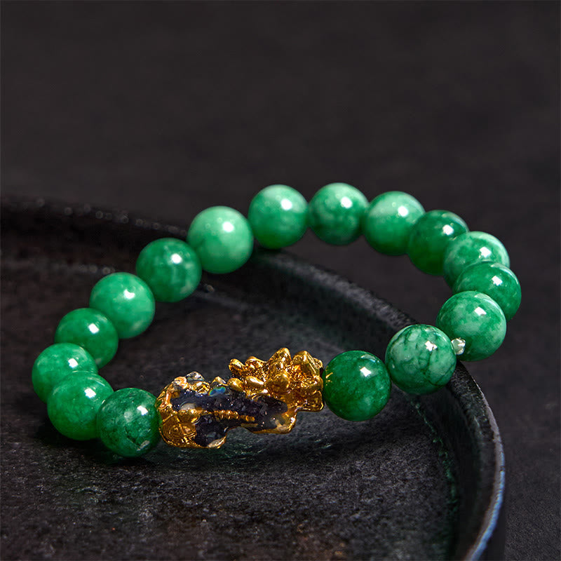 PiXiu Jade Bracelet – On black ceramic plate showing glossy green jade beads and gold PiXiu