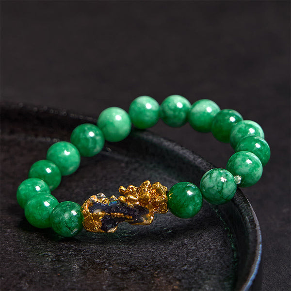 PiXiu Jade Bracelet – On black ceramic plate showing glossy green jade beads and gold PiXiu