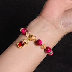 Red Tiger Eye PiXiu Fox Bracelet – Wrist wearing red tiger eye PiXiu bracelet black bg, feminine