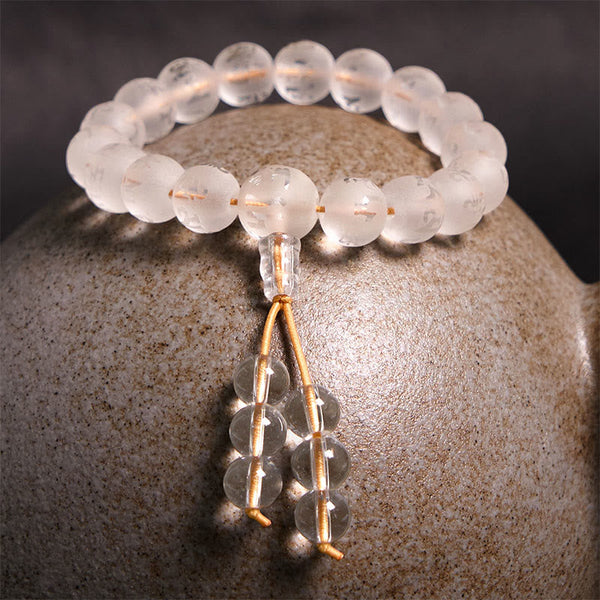 White Crystal Mantra Bracelet – Draped on artisan ceramic pot, earthy meditation styling