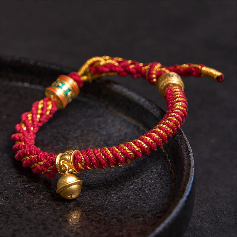 Zakiram Om Mani Padme Hum Charm Bracelet – Red gold braid close-up on dark ceramic, traditional lucky bracelet