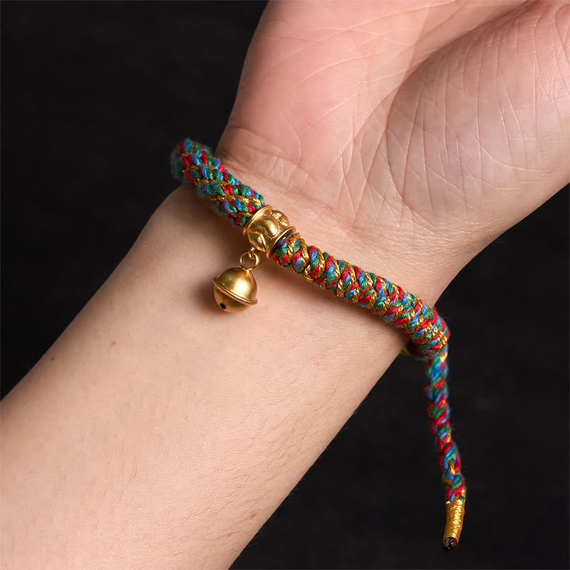 Zakiram Om Mani Padme Hum Charm Bracelet – Worn on wrist showing colorful braid and gold bell, close-up fit view