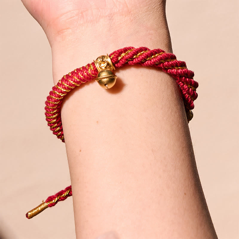 Zakiram Om Mani Padme Hum Charm Bracelet – On wrist against neutral background, gold bell and braid texture visible