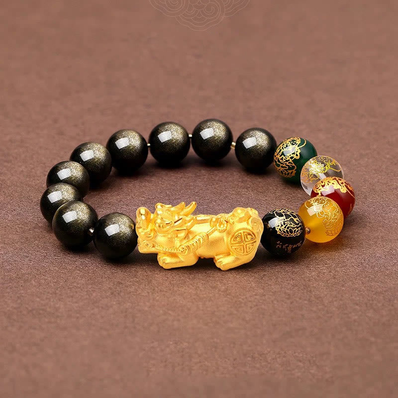 Gold Sheen Obsidian PiXiu Bracelet – flat lay on brown fabric, gold PiXiu center, black obsidian beads, rich
