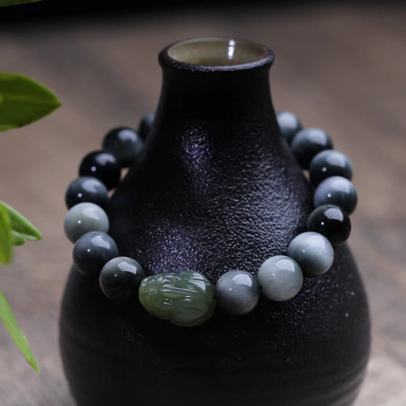 Eagle's Eye Jade PiXiu Bracelet – bracelet on black ceramic vase, gray-blue beads with green PiXiu, zen decor