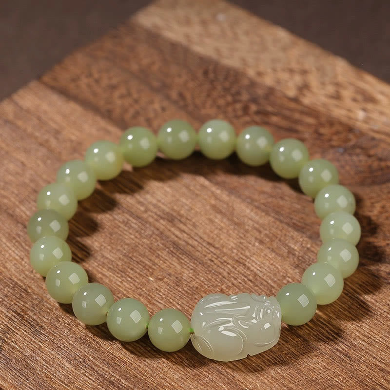 Hetian Jade PiXiu Bracelet – light green jade beads with PiXiu on rustic wood, natural texture background
