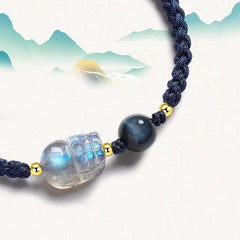 Moonstone PiXiu Tiger Eye Couple Bracelet – close-up moonstone PiXiu with blue tiger eye, mountain watercolor art background