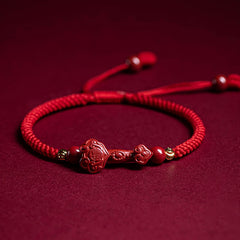 Cinnabar Ruyi Fu PiXiu Red Bracelet – single Ruyi bracelet flat on red velvet with adjustable cord, front view