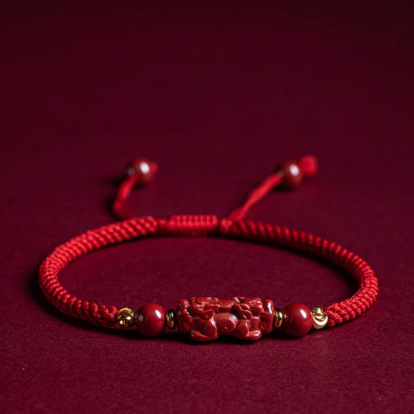 Cinnabar Ruyi Fu PiXiu Red Bracelet – PiXiu bracelet laid flat on red velvet front view, wealth mascot jewelry