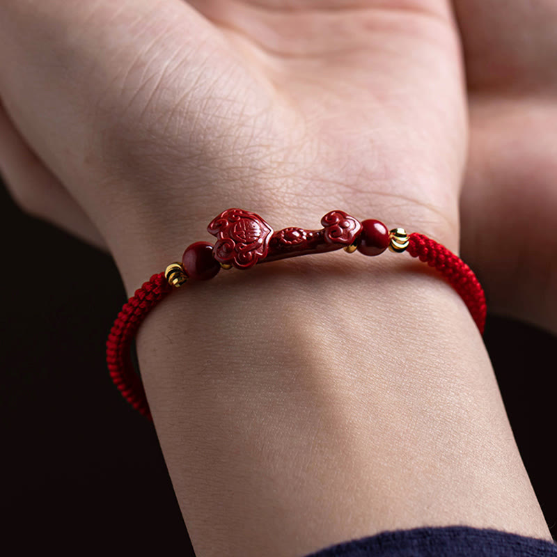 Cinnabar Ruyi Fu PiXiu Red Bracelet – Ruyi bracelet worn on woman's wrist close-up, dark background, blessing jewelry