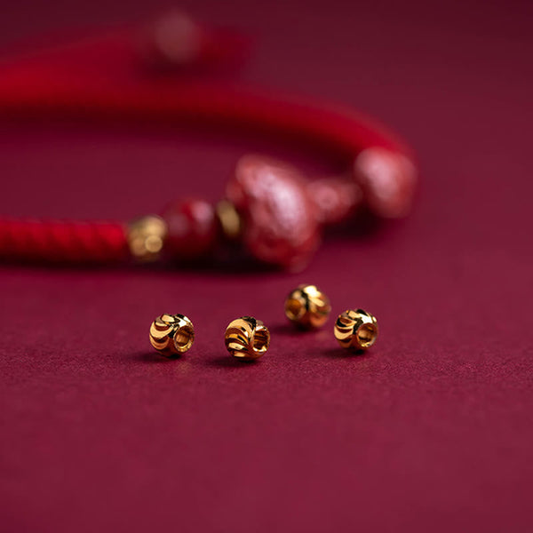 Cinnabar Ruyi Fu PiXiu Red Bracelet – close-up gold spacer beads with bracelet blurred, red velvet background