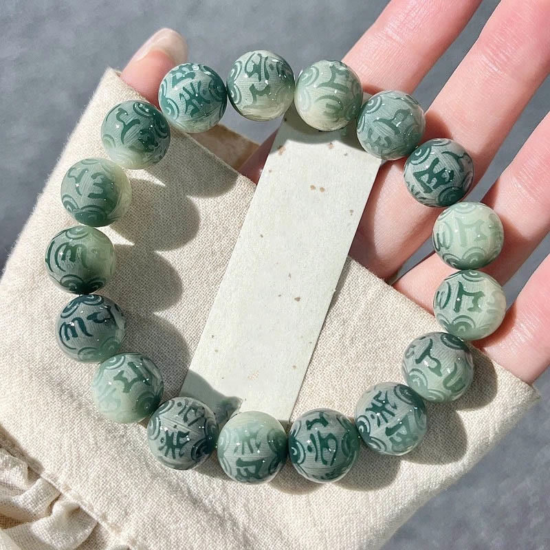 Chinese Zodiac Wisdom Bracelet – Mint green carved mantra beads resting on palm, Bodhi seed style
