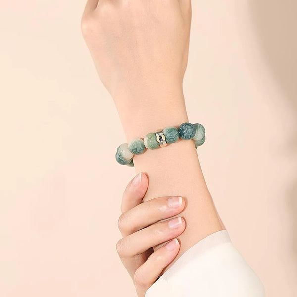 Chinese Zodiac Wisdom Bracelet – Worn on wrist showing carved green beads with silver mantra accent