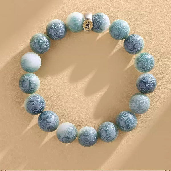 Chinese Zodiac Wisdom Bracelet – Blue-white ombre stone beads with engraved zodiac charm, overhead view