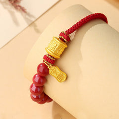 Sterling Silver Cinnabar Bracelet – Worn on mannequin wrist showing red beads and gold accents, adjustable cord bracelet