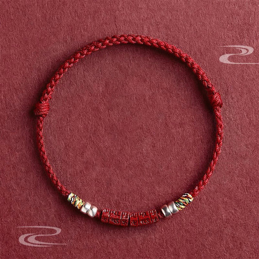 Cinnabar Om Mani Padme Hum Red String Bracelet – flat lay with carved mantra beads and silver accents, blessing protection