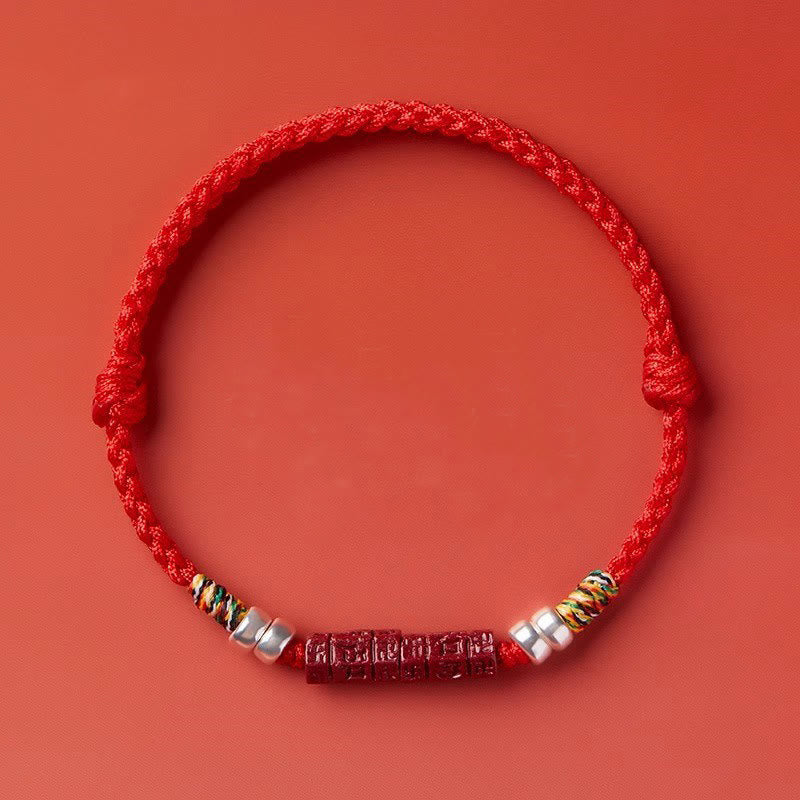 Cinnabar Om Mani Padme Hum Red String Bracelet – top view on red surface, adjustable knot closure