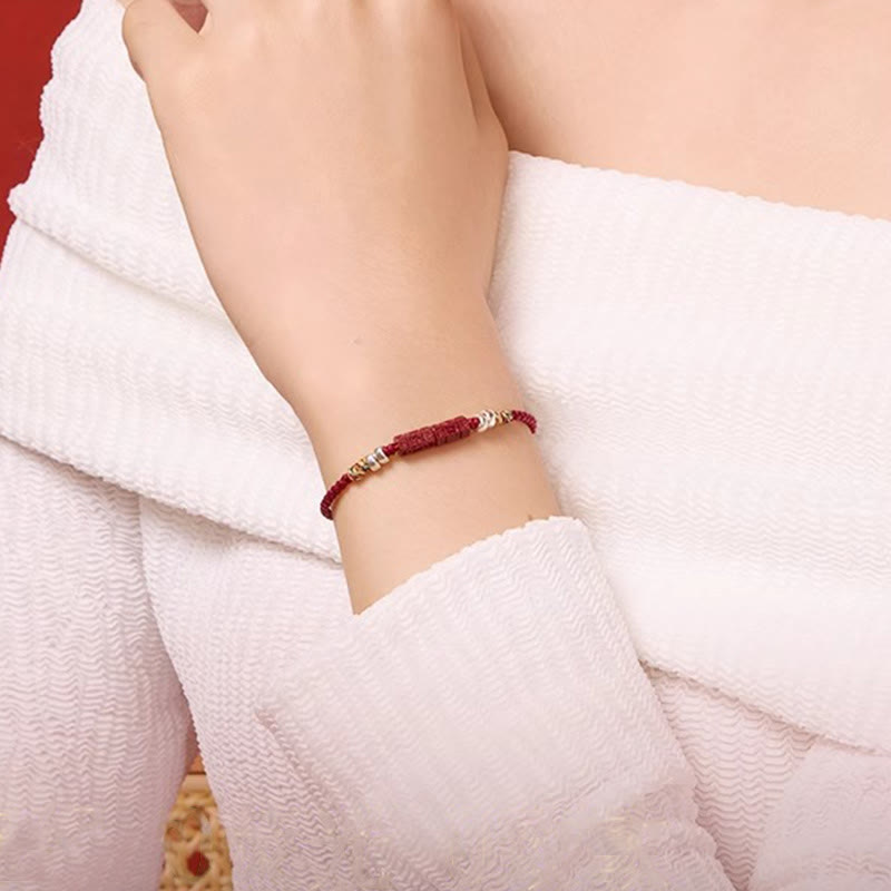 Cinnabar Om Mani Padme Hum Red String Bracelet – lifestyle wrist shot with white blouse, zen accessory