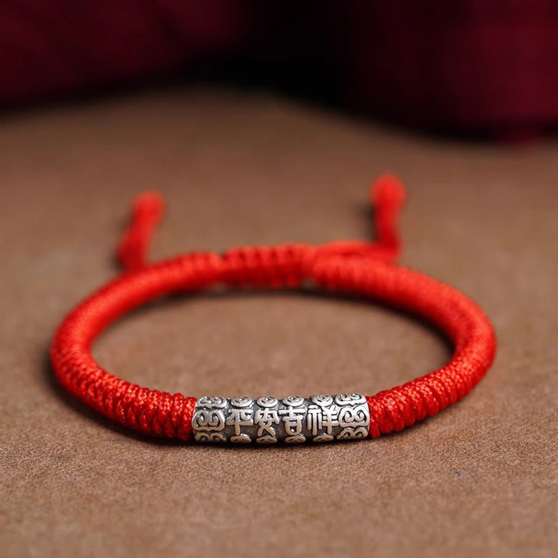 Silver Mantra Rope Bracelet – Red cord bracelet with silver blessing bead on suede background, adjustable knot closure