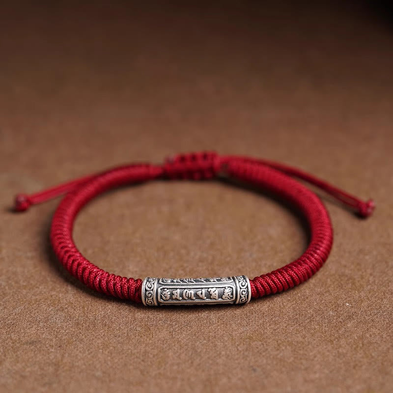 Silver Mantra Rope Bracelet – Red woven cord with oxidized silver mantra bead on craft paper, protection bracelet