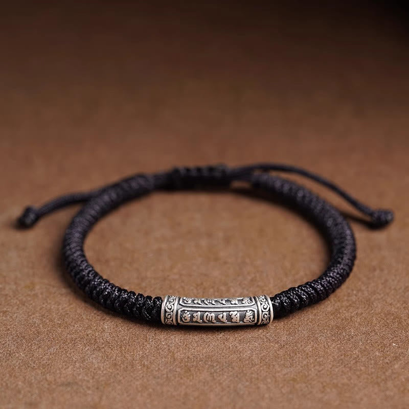 Silver Mantra Rope Bracelet – Black cord with oxidized silver mantra bead on brown surface, spiritual bracelet