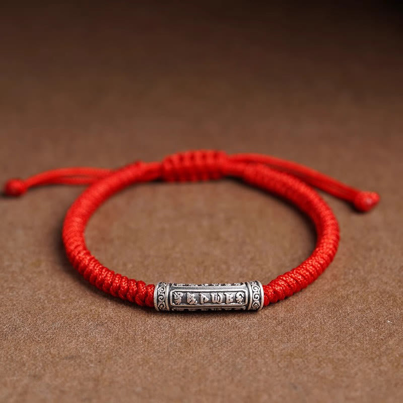 Silver Mantra Rope Bracelet – Red cord with silver bead showing six mantra characters on kraft paper, lucky charm