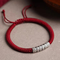 Silver Mantra Rope Bracelet – Red cord bracelet with silver blessing bead on neutral textured background, Chinese lucky br...