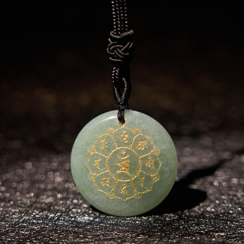 Om Mani Padme Hum Necklace – Green aventurine with gold Buddhist engraving on dark moody surface, jade crystal